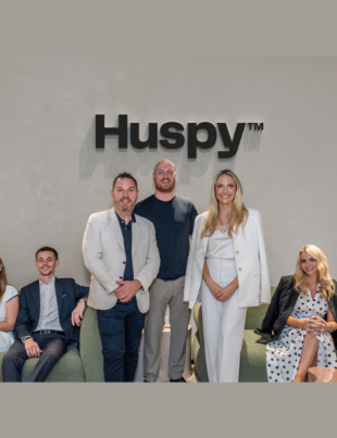 Standing (left to right) Patrick Hayden, Founder, LuxuryX, Mark Castley, CEO of Real Estate, Huspy and Georgia Peacock, with members of the LuxuryX team (Image Courtesy: PRNewswire)